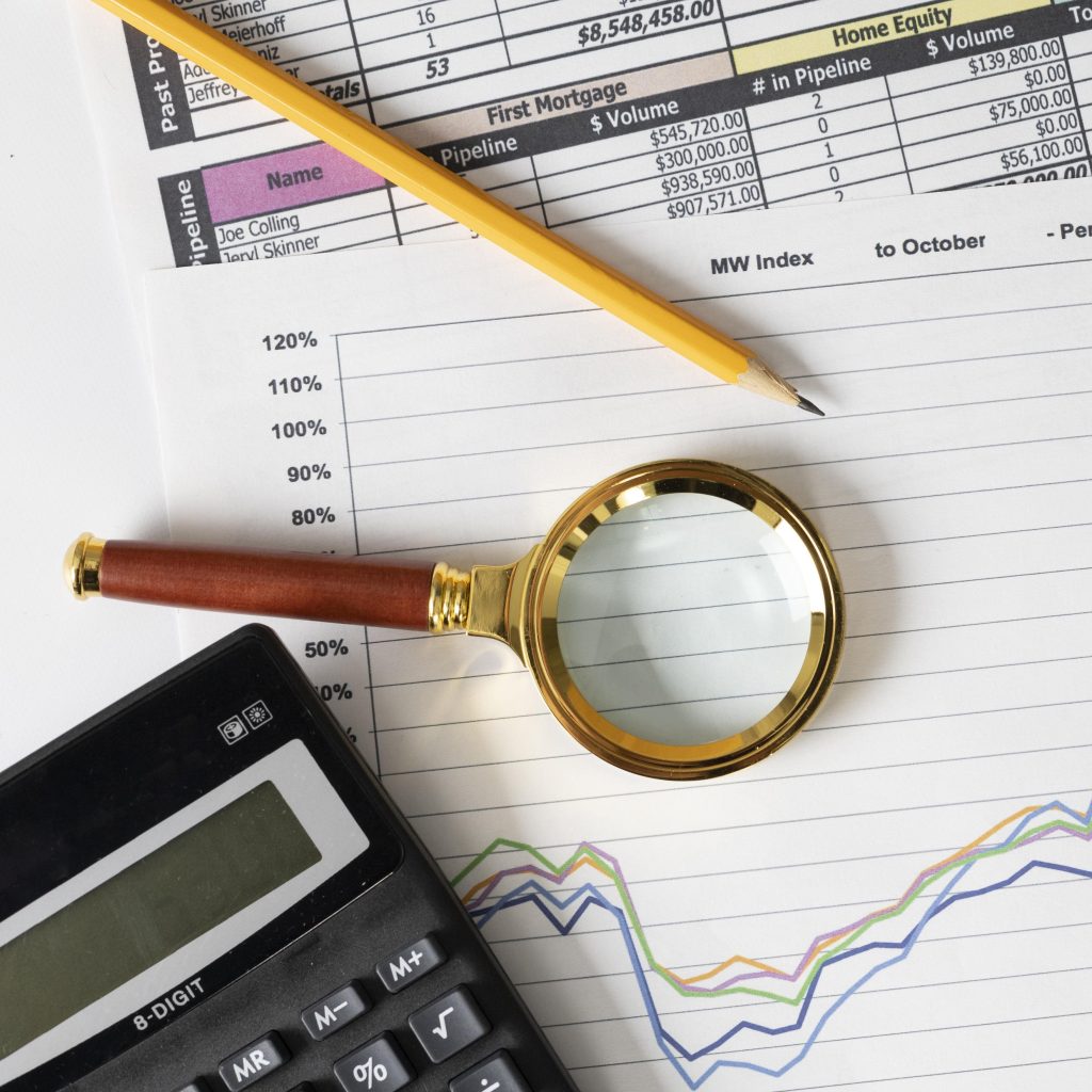 Financial recruitment concept with charts, calculator, and magnifying glass showing staffing trends