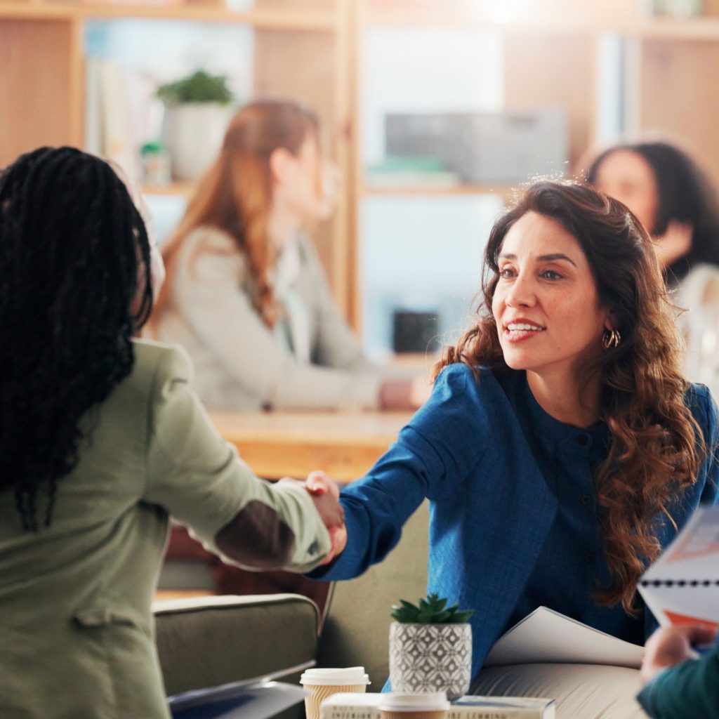Employer shaking hands with job candidate during successful recruitment interview in modern office