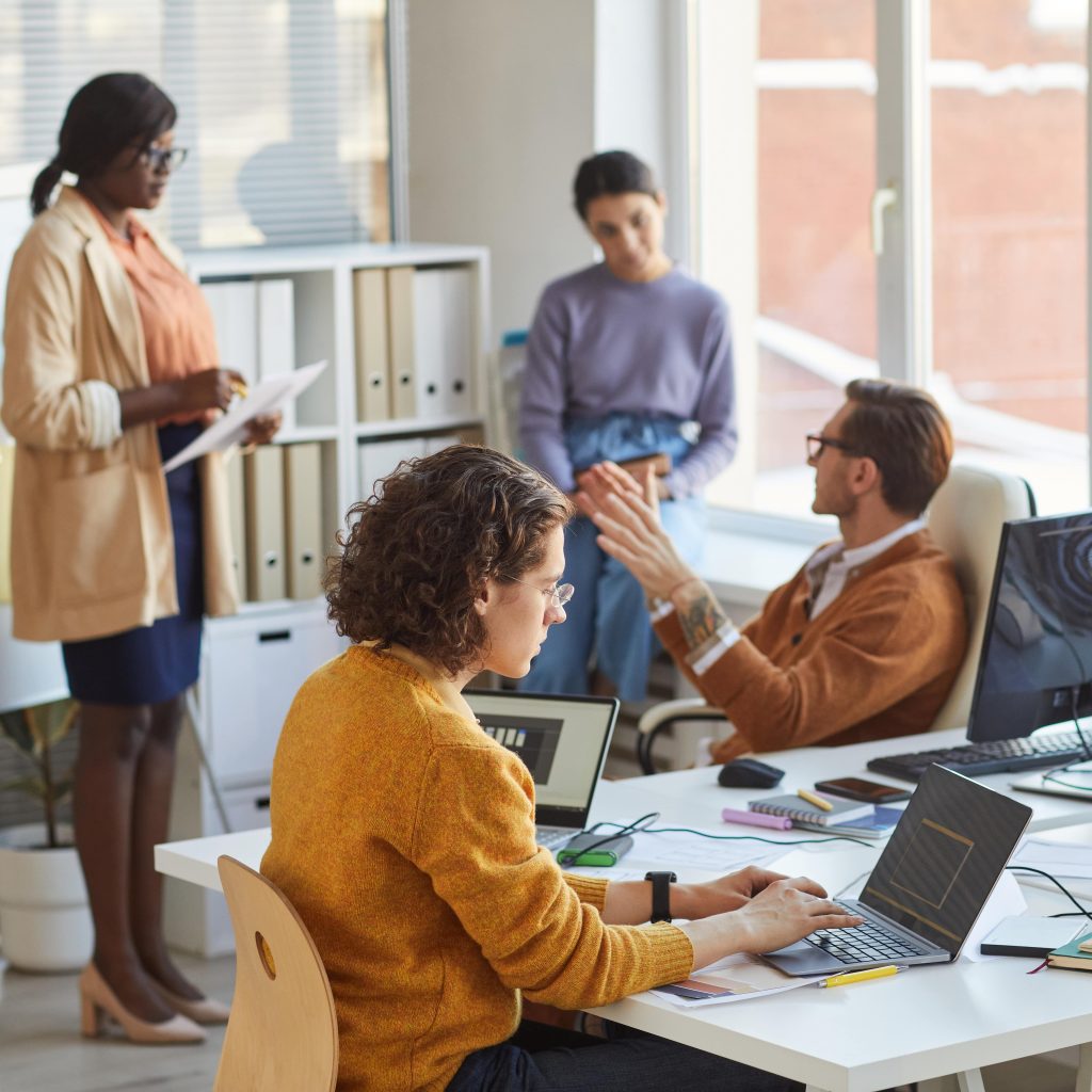 Professional team collaborating on hiring strategy in bright modern workspace — recruitment services for office support roles