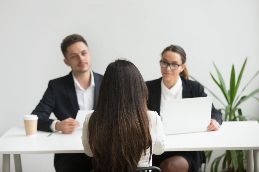 Hiring managers interviewing job candidate — recruitment agency services for office and professional roles